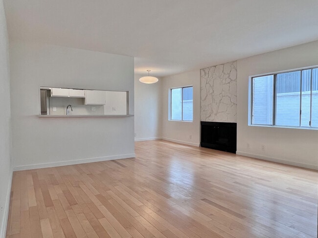 Bright, spacious living room with maple hardwood floors, fireplace, and excellent natural light. - 11639 Chenault St