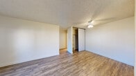 Located at 39655 Trinity Way in Fremont, CA, this one-bedroom, one-bathroom unit offers a practical and well-organized single-floor layout. The living room is bright and inviting, featuring wood-style plank flooring, a textured ceiling, a baseboard heating unit, and a sliding glass door that opens to a private patio and brings in natural light and outdoor views. The kitchen is efficiently designed with white cabinetry, neutral stone-tone countertops, a stainless steel sink, and a window overlooking the outdoors, providing natural ventilation and light. A dishwasher is also included. The bedroom is carpeted for comfort and includes a sliding-door closet with built-in shelving, a ceiling fan with light fixture, and a window with views of the surrounding area. An additional walk-in closet with dual hanging rods and carpeted flooring provides generous storage. The full bathroom features wood-style flooring, a white vanity with a single sink, a large mirror, and a tub and shower combination. A hallway connects all rooms, contributing to the unit's efficient flow. Throughout, neutral tones and clean finishes create a functional and cohesive living environment.