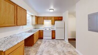 Located at 1521 E Grand Blvd in St. Louis, Missouri, this two-story, two-bedroom, two-bathroom home offers a straightforward and functional layout spread across two floors. The main floor provides a welcoming living area, a kitchen, and a full bathroom. The kitchen is well-equipped with warm honey-toned wood cabinetry, light granite-style countertops, a double sink, white appliances including a range and refrigerator, and tile flooring that extends into the adjacent dining area. A full bathroom on this level features a clean white vanity with cabinet storage, a mirrored medicine cabinet, and tile flooring. Upstairs, the two carpeted bedrooms offer a comfortable and quiet retreat. The primary bedroom is generously sized, featuring a double-door closet, a window with natural light, and access to the hallway. The second bedroom is similarly carpeted with neutral walls and a window overlooking greenery. The upper-level bathroom includes a full tub-shower combination with a white tile surround, chrome fixtures, and tile flooring. Throughout the home, cream-colored walls, white trim, and consistent flooring choices create a clean, cohesive aesthetic. A staircase connects both levels, completing this practical and move-in-ready home.