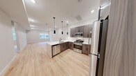 Located at 18 Lane Ave in Caldwell, NJ, this well-appointed 2-bedroom, 1-bathroom residence showcases a contemporary design with clean lines and a bright, modern aesthetic. Light hardwood flooring extends throughout the entire space, creating a warm and cohesive feel.

The open-concept kitchen and living area serves as the heart of the home. The kitchen is outfitted with sleek, wood-grain cabinetry in a warm gray-brown tone, crisp white countertops, and a full suite of stainless steel appliances — including a gas range, over-the-range microwave, dishwasher, and refrigerator. Stylish matte black pendant lights hang above the peninsula, which also features an undermount sink, adding a striking design accent. Recessed lighting and a window allow natural light to brighten the open living area beyond.

Both bedrooms are finished with the same hardwood flooring and neutral walls, offering a calm and versatile space. Each room benefits from natural light through windows with fitted blinds.

The bathroom features dark tile flooring, a full tub-and-shower combination enclosed by a frameless sliding glass door, and matte black fixtures that echo the modern hardware found throughout the home. The result is a cohesive, stylish residence that balances comfort with contemporary design.