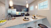 Located at 2545 Croquet Dr in Wilmington, NC, this two-story home offers a well-designed layout with modern finishes throughout. The kitchen is a standout feature, showcasing dark shaker-style cabinetry, granite countertops, stainless steel appliances, and elegant pendant lighting above a generous breakfast bar — ideal for both everyday cooking and entertaining. Light-toned luxury vinyl plank flooring runs through the main living areas, complementing the neutral color palette that creates a bright and cohesive atmosphere. Multiple bedrooms are spread across both floors, each featuring ceiling fans and ample natural light through white-trimmed windows with blinds. Several bedrooms include built-in closets with shelving for organized storage. Carpeted bedrooms on the upper level add warmth and comfort. The bathrooms are well-appointed, with dark vanity cabinetry, granite countertops, and light wood-look flooring. The primary bathroom features a glass-enclosed walk-in shower, while a secondary bathroom offers a full tub-shower combination. A half bath provides added convenience. A dedicated laundry room with full-size washer and dryer hookups and overhead shelving adds practical utility to this thoughtfully designed home.