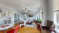 This well-appointed single-floor home offers four bedrooms, two bathrooms, and a thoughtfully designed layout that balances communal living with private spaces. The living room serves as the heart of the home, showcasing warm hardwood floors, elegant crown molding, a ceiling fan, and large windows that invite generous natural light. Graceful arched doorways and a built-in shelving unit add distinctive architectural character to the space.

The kitchen features granite countertops, dark cabinetry with gold hardware, a subway tile backsplash, and a window with exterior views, providing both functionality and style. Both bathrooms are finished with granite-topped vanities and dark cabinetry; one bathroom is fully tiled in large-format white subway tile from floor to ceiling, creating a clean, modern aesthetic.

The four bedrooms are comfortably sized, each with hardwood floors and windows offering natural light. The primary bedroom is notably spacious, with room for a full furniture arrangement. Additional closets throughout — six in total — provide ample storage. The home also includes a dedicated laundry room, a pantry, and a utility room, rounding out a highly functional floor plan suited for shared or family living.
