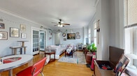 This well-appointed single-floor home offers four bedrooms, two bathrooms, and a thoughtfully designed layout that balances communal living with private spaces. The living room serves as the heart of the home, showcasing warm hardwood floors, elegant crown molding, a ceiling fan, and large windows that invite generous natural light. Graceful arched doorways and a built-in shelving unit add distinctive architectural character to the space.

The kitchen features granite countertops, dark cabinetry with gold hardware, a subway tile backsplash, and a window with exterior views, providing both functionality and style. Both bathrooms are finished with granite-topped vanities and dark cabinetry; one bathroom is fully tiled in large-format white subway tile from floor to ceiling, creating a clean, modern aesthetic.

The four bedrooms are comfortably sized, each with hardwood floors and windows offering natural light. The primary bedroom is notably spacious, with room for a full furniture arrangement. Additional closets throughout — six in total — provide ample storage. The home also includes a dedicated laundry room, a pantry, and a utility room, rounding out a highly functional floor plan suited for shared or family living.