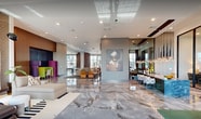 Located at 4475 N Scott Robinson Blvd in Las Vegas, NV, this 5,180-square-foot single-floor amenity center is designed with a modern, upscale aesthetic. The space is anchored by sweeping polished marble-look flooring that flows throughout, complemented by high ceilings and floor-to-ceiling windows that flood the interior with natural light and offer views of the surrounding outdoor pool area and landscaping.

The fitness center is expansive and well-equipped, featuring a full array of cardio machines including treadmills, ellipticals, and stationary bikes, alongside a multi-station cable machine, free weights with adjustable benches, and full-length mirrors. Large windows provide natural light and outdoor views, enhancing the workout environment.

The clubroom and lounge area offers a sophisticated gathering space with a pool table set on gleaming marble-look floors, a bar-height island with teal tile accents and pendant lighting, open shelving with books and games, and a large-screen TV entertainment wall with plush seating. A private lounge nook features elegant draping curtains and curated furniture.

The mailroom corridor is elegantly appointed with rows of white mailboxes lining both walls, decorative abstract artwork, a geometric tile floor inlay, a copper penny-tile accent wall, and a statement globe chandelier—elevating an everyday functional space into a design feature.