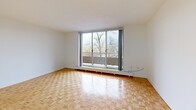 Located at 100 Eighth Ave in Kitchener, Ontario, this one-bedroom, one-bathroom unit offers a practical and comfortable layout across a single floor. Warm parquet flooring runs throughout the living areas and bedroom, lending a classic character to the space. The bright living room is highlighted by a large sliding glass door that opens to a private balcony, where red brick exterior walls frame relaxing views of tree-lined streets and green surroundings below. The kitchen features crisp white cabinetry, marble-look countertops, a stainless steel range, and a window that fills the space with natural light. The bedroom is a comfortable size, offering a built-in closet, a window overlooking the outdoors, and baseboard heating. The bathroom is clean and functional, finished with white tile, a soaker tub with shower, a marble-top vanity, and a window for natural ventilation. A hallway connects the rooms efficiently, completing a well-organized floor plan. The unit's elevated position provides pleasant outdoor views and a sense of openness throughout.