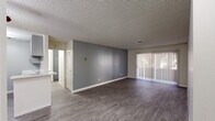 Located in Scottsdale, Arizona, this two-bedroom, two-bathroom residence offers a well-designed single-level layout with contemporary updates throughout. The open living area is a welcoming centerpiece, featuring durable wood-style flooring, a neutral gray accent wall, and a full-width sliding glass door with vertical blinds that floods the space with natural light and provides access to an outdoor patio area with tree-lined views.

The kitchen is thoughtfully appointed with gray shaker-style cabinetry, quartz countertops, a subway tile backsplash, a stainless steel sink, and matching stainless steel appliances including a gas range and refrigerator. A peninsula counter connects the kitchen to the living area, enhancing the open feel.

Both bedrooms feature wood-style flooring, neutral wall tones, and windows that bring in natural light. The spacious primary bedroom includes a sliding-door closet for ample storage. The bathrooms are clean and modern, with one featuring a gray vanity with updated hardware, a well-lit mirror, and a tub-shower combination with white tile surround. Textured ceilings are consistent throughout the home, adding a classic Southwestern residential character to the overall aesthetic.