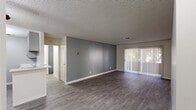 Located in Scottsdale, Arizona, this two-bedroom, two-bathroom residence offers a well-designed single-level layout with contemporary updates throughout. The open living area is a welcoming centerpiece, featuring durable wood-style flooring, a neutral gray accent wall, and a full-width sliding glass door with vertical blinds that floods the space with natural light and provides access to an outdoor patio area with tree-lined views.

The kitchen is thoughtfully appointed with gray shaker-style cabinetry, quartz countertops, a subway tile backsplash, a stainless steel sink, and matching stainless steel appliances including a gas range and refrigerator. A peninsula counter connects the kitchen to the living area, enhancing the open feel.

Both bedrooms feature wood-style flooring, neutral wall tones, and windows that bring in natural light. The spacious primary bedroom includes a sliding-door closet for ample storage. The bathrooms are clean and modern, with one featuring a gray vanity with updated hardware, a well-lit mirror, and a tub-shower combination with white tile surround. Textured ceilings are consistent throughout the home, adding a classic Southwestern residential character to the overall aesthetic.