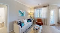 This thoughtfully designed 2-bedroom, 2-bathroom residence offers a single-floor open-concept layout that seamlessly connects the living, dining, and kitchen areas. The living room features crown molding, plush carpeting, and large windows dressed with sheer drapes and horizontal blinds that invite an abundance of natural light. A glass-top coffee table, neutral-toned sofa, and a leather accent chair complement the relaxed yet refined atmosphere.

The kitchen is outfitted with white shaker cabinetry, granite countertops, a classic white subway tile backsplash, stainless steel appliances, and a peninsula that opens to the living area. Adjacent to the kitchen, the dining area benefits from multiple windows and a pendant light fixture, creating a bright and inviting space for meals.

Both bedrooms are carpeted and well-lit, each featuring windows with sheer patterned curtains that provide privacy while allowing natural light. The two bathrooms mirror each other in style, each showcasing granite-topped vanities, wood-look flooring, and tub-shower combinations with tile surrounds. Throughout the residence, a cohesive neutral color palette, wood-look flooring in wet areas, and consistent finishes create a clean, modern, and comfortable living environment.