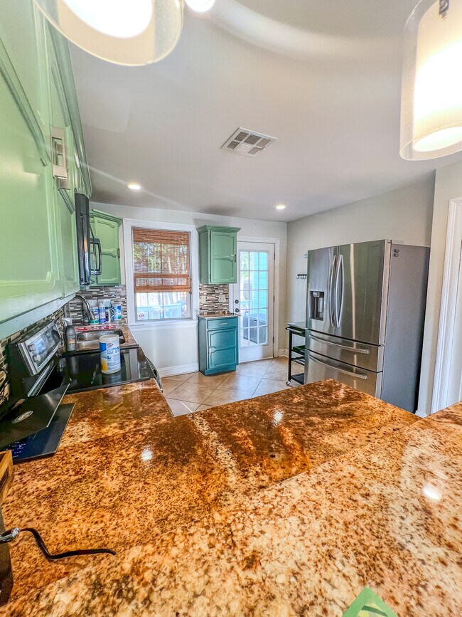 Kitchen with granite countertops and updated appliances. Induction-stove (better than gas!) - 5717 Pasteur Blvd