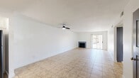 Located in Cathedral City, California, this single-floor, 3-bedroom, 2-bathroom home offers a well-organized and functional layout with clean finishes throughout. The open living room is bright and inviting, featuring large-format tile flooring, a ceiling fan, and a fireplace framed by a sliding glass door that opens to a private patio, filling the space with natural light and providing easy outdoor access. The adjacent kitchen has been thoughtfully updated with two-tone cabinetry — white upper cabinets and gray lower cabinets — complemented by a white quartz-style countertop, a hexagonal tile backsplash, black appliances including a gas range, and a window overlooking the exterior. The three bedrooms feature wood-look plank flooring and windows with vertical blinds that allow for adjustable natural light. The primary bedroom includes a walk-in closet, while another bedroom offers a built-in sliding door closet. Both bathrooms are finished in clean white tones, each equipped with a full shower-tub combination and vanity with mirror. A hallway connects the bedrooms and bathrooms, keeping the layout efficient and private. The home presents a move-in ready, well-maintained living environment in a desirable desert community.