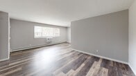 Located at 1424 Nottingham Way in Trenton, NJ, this single-floor, two-bedroom, one-bathroom unit offers a thoughtfully laid-out living space. Throughout the unit, warm-toned luxury vinyl plank flooring in a rustic wood finish provides a cohesive and modern aesthetic against neutral gray walls and crisp white trim and baseboards.

The living area is bright and open, featuring a large window that draws in natural light and offers views of the surrounding neighborhood. A baseboard heating system and window air conditioning unit ensure year-round comfort. The kitchen, visible in the floor plan, is arranged in an L-shape with white cabinetry, a gas range, and a refrigerator, making efficient use of the available space.

The spacious primary bedroom is generously proportioned, featuring a built-in closet with sliding doors and access to the hallway. The second bedroom is also well-sized, with a window that provides natural light and outdoor views. A connecting hallway links the rooms efficiently.

The bathroom is a standout feature, finished with large-format marble-look porcelain wall tiles surrounding the soaking tub and shower combination. A gray vanity with a white basin sink, a medicine cabinet mirror, and a frosted privacy window complete the clean, polished look of this well-appointed space.
