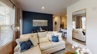 Located at 50 Cheryl Lane in Summerville, South Carolina, this single-floor residence offers a thoughtfully designed layout with modern finishes and a cohesive aesthetic throughout. The open-concept living and dining area serves as the heart of the home, anchored by a bold navy accent wall, light wood-style flooring, and large windows that invite generous natural light and outdoor views. The seamless flow connects to a well-equipped kitchen featuring white shaker cabinetry, granite countertops, a subway tile backsplash, and a full suite of stainless steel appliances, including a refrigerator, dishwasher, microwave, and range. A breakfast bar provides additional seating and reinforces the open feel. The primary bedroom is a serene retreat with a ceiling fan, plush carpeting, a window overlooking the surrounding landscape, and an en-suite bathroom with a glass-enclosed walk-in shower. The second bedroom features its own ceiling fan, carpeted flooring, and a dedicated dresser alcove with natural light. A second full bathroom includes a tub-shower combination. Throughout the residence, neutral wall tones, clean lines, and carefully considered design details create a comfortable and welcoming atmosphere.