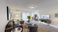 This single-floor, 2-bedroom, 1-bathroom residence offers a thoughtfully designed open layout that maximizes functionality and comfort. The combined living and dining area forms the heart of the home, featuring plush carpeting, soft neutral tones, and a sliding glass door that floods the space with natural light and provides outdoor access. The living room offers generous room for seating arrangements, while the adjacent dining area includes hardwood-style flooring and a bright window view.

The kitchen is well-equipped with rich dark cabinetry, granite countertops, stainless steel appliances including a gas range, microwave, dishwasher, and refrigerator, along with a breakfast bar and track lighting overhead. Hardwood-style flooring ties the kitchen seamlessly to the adjoining spaces.

The spacious primary bedroom features a bold accent wall, plush carpet, and multiple windows that invite natural light, complemented by a walk-in closet with built-in wire shelving. The second bedroom is cozy and bright, with carpet flooring and a reach-in closet.

The bathroom is finished with marble-style tile surrounding a tub-shower combination, a dark wood vanity with granite countertop, and wood-look flooring. Two hallways provide smooth circulation throughout, completing this well-organized and stylish home.