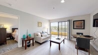 Located at 12751 Gateway Park Road in Poway, California, this single-story residence offers a thoughtfully designed layout with a bright, cohesive aesthetic throughout. The living area serves as the heart of the space, featuring light wood-style flooring, neutral walls, and large sliding glass doors that open to a private balcony. The balcony frames scenic outdoor views of the surrounding Poway landscape, flooding the interior with natural light and creating an inviting, airy atmosphere.

Adjacent to the living area, a compact and efficiently arranged kitchen features white cabinetry extending to the upper walls, granite-style countertops, and full appliances including a range, refrigerator, and dishwasher. Light flooring continues from the living space, maintaining a consistent, clean visual flow.

The bedroom is generously proportioned, with plush carpet underfoot and multiple large windows that frame views of the hillside landscape, contributing to the room's calm, restful character. Neutral tones and ample natural light define the space.

The bathroom is finished with an extended granite-topped vanity, white cabinetry with brushed nickel hardware, a framed mirror with overhead lighting, and a separate walk-in shower. The overall design throughout the unit balances functionality with a polished, welcoming ambiance suited to comfortable everyday living.