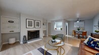Located at 8800 Dunwoody Pl in Sandy Springs, GA, this single-floor residence offers a thoughtfully designed layout with a warm, modern aesthetic throughout. The expansive living room serves as the heart of the home, anchored by a classic wood-burning fireplace framed by built-in shelving on either side — an ideal focal point for relaxing or entertaining. Light hardwood flooring flows continuously through the main living areas, enhancing the sense of openness and cohesion. A pass-through window connects the living area to the kitchen, which features gray cabinetry, white countertops, and a subway tile backsplash, creating a clean and contemporary look. Adjacent to the kitchen, the dining area comfortably accommodates a round table and provides a defined yet connected space for meals. A sunlit bonus room with large windows on multiple walls offers an inviting retreat, well-suited as a home office or reading nook. The bathroom showcases gray vanity cabinetry with modern hardware and a white countertop. A dedicated in-unit laundry closet with shelving adds practical convenience. Throughout, a neutral gray-and-white palette, consistent flooring, and modern finishes give the space a clean, well-appointed character with a welcoming ambiance.