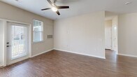 Located at 8816 Aspinwall Dr in Charlotte, NC, this well-appointed single-story home offers three bedrooms, two bathrooms, and a thoughtfully designed open-concept layout. The combined kitchen, dining, and living area forms the heart of the home, featuring rich hardwood-style flooring, neutral toned walls, and abundant natural light streaming through large windows and glass patio doors. The kitchen is a standout, equipped with dark espresso cabinetry extending to the ceiling, granite countertops, a curved peninsula island with an undermount sink, pendant lighting, and a full suite of black appliances including a refrigerator, range, and built-in microwave. The living area is spacious and bright, accented by a ceiling fan and direct access to the patio. The primary bedroom offers plush carpeting, a ceiling fan, and generous closet space. Its en-suite bathroom features a dual-sink vanity with granite countertops, dark cabinetry, and a walk-in closet. The secondary bathroom includes a granite vanity, a tub/shower combo, and a bright window. Additional bedrooms are carpeted with ceiling fans. The home also includes a dedicated laundry area, a hallway, and four closets for ample storage throughout.