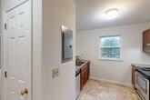 This two-story, two-bedroom, one-bathroom home in South Burlington, Vermont offers a practical and comfortable layout across two well-proportioned floors. The main level features a combined living and dining area with carpet flooring, which opens to a kitchen equipped with warm wood cabinetry, granite-style countertops, stainless steel appliances including a range and refrigerator, and tile flooring. A pass-through counter connects the kitchen to the living space, enhancing the open feel. Natural light filters through multiple windows, and a balcony provides outdoor access. The upper level houses both bedrooms, each with soft carpet flooring and generous closet space featuring bi-fold doors. The primary bedroom includes dual windows that bring in ample natural light and offer pleasant outdoor views. The full bathroom on this floor includes a soaking tub and shower combination with tile flooring. Throughout the home, four closets provide excellent storage. A staircase with a wooden handrail connects the two floors. The neutral color palette and clean finishes create a bright, understated ambiance throughout this well-organized South Burlington residence.