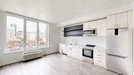 Located at 1201 Vine St in Philadelphia's vibrant Chinatown neighborhood, this thoughtfully designed one-bedroom, one-bathroom unit offers a clean, modern aesthetic throughout. Light-toned luxury vinyl plank flooring runs continuously across the single floor, complementing the bright white walls and creating a cohesive, airy feel.

The open-concept living, dining, and kitchen area forms the heart of the unit. The kitchen is well-appointed with white cabinetry, floating dark wood shelves, a geometric patterned tile backsplash, and a full suite of stainless steel appliances including a range, microwave, dishwasher, and refrigerator. A large window frames views of the Philadelphia cityscape, filling the space with natural light.

A long hallway connects the main living area to the private bedroom, which is a comfortable size and features two closets, providing ample storage. In-unit laundry adds everyday convenience.

The bathroom is a standout feature, finished with floor-to-ceiling marble-style tile, a glass-enclosed walk-in shower with a built-in niche, a wood-toned vanity with a white countertop, and a backlit mirror — delivering a spa-like atmosphere. The overall design is clean, modern, and move-in ready.