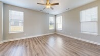 Located in Nashville, Tennessee, this two-story home offers four bedrooms and four bathrooms thoughtfully distributed across two well-proportioned floors. The main level hosts the combined kitchen and living area, an attached garage, and connecting hallways, while the upper level dedicates more space to the bedrooms and additional living areas.

The kitchen is outfitted with gray shaker-style cabinetry, white quartz countertops, stainless steel appliances, and durable wood-look luxury vinyl plank flooring — a consistent finish found throughout the home. Neutral, light gray walls lend a clean and modern aesthetic to every room.

Each bedroom benefits from natural light streaming through slatted blinds, with the generously sized primary bedroom providing a comfortable private retreat. The bathrooms feature white tub-shower combinations with built-in shelving, complemented by simple, functional vanities. The dedicated laundry room stands out with its built-in cabinetry, white quartz folding surface, wire shelving, and full-size washer hookup — a practical and well-appointed space.

The attached garage provides ample room for vehicles and storage, featuring a standard automatic door with windows for natural light. Throughout, the home presents a fresh, move-in-ready interior with consistent finishes and a clean, contemporary design.