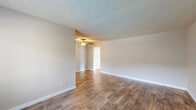 Located in the 92107 zip code of San Diego, CA, this one-bedroom, one-bathroom unit offers a well-designed layout across a single floor. The living area is bright and open, featuring durable wood-style flooring, neutral-toned walls, a textured ceiling, and a ceiling fan with light fixture. A large window near the entry door allows natural light to fill the room, offering a view of the surrounding outdoor greenery.

The galley-style kitchen is efficiently arranged with white cabinetry, dark granite-look countertops, black appliances including a gas range and refrigerator, and a stainless steel sink. A window above the sink provides additional natural light into the kitchen space.

The bedroom is carpeted for comfort, featuring a ceiling fan, multiple windows with blinds that bring in natural light, and a mirrored sliding closet that adds a sense of depth to the room. The soft, neutral carpet complements the light gray walls throughout.

The bathroom includes a full tub-shower combination with white tile surround, a small window for ventilation, wood-style flooring, and a dark granite vanity countertop. A hallway connects the main living spaces, and a dedicated closet adds practical storage. The overall ambiance is clean, functional, and move-in ready.