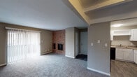 This single-story residence offers a well-organized floor plan with clearly defined living spaces throughout. The living room serves as a central focal point, highlighted by a striking floor-to-ceiling brick fireplace that adds warmth and character to the space. Neutral-toned walls and plush carpeting carry throughout the main living and bedroom areas, creating a cohesive and comfortable atmosphere. Large vertical blinds and windows allow natural light to filter in, enhancing the open feel of the main living area.

Adjacent to the living room, a dedicated dining area features a ceiling fan and direct sightlines into the kitchen, supporting an efficient and connected layout. The kitchen is well-appointed with white shaker-style cabinetry, granite-look countertops, black appliances including a refrigerator, range, and dishwasher, and wood-look flooring that provides a clean contrast to the surrounding spaces.

The bedrooms are generously proportioned, each featuring plush carpet, neutral walls, and access to natural light through blinds-covered windows. One bedroom includes an attached walk-in closet and access to a bathroom. The bathroom features a granite-top vanity with white cabinetry, a wall mirror, and a tub-shower combination, finished with wood-look flooring for a polished look.