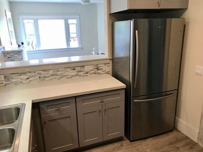 Gorgeous custom kitchen, with quartz countertops, mosaic tile backsplash, stainless steel fridge - 3031 E 7th St