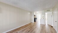 Located at 747 N Azusa Ave in West Covina, CA, this well-appointed one-bedroom, one-bathroom unit offers a thoughtfully designed single-floor layout with a clean, modern aesthetic throughout. Light-toned luxury vinyl plank flooring flows seamlessly across every room, complementing the neutral, warm-beige walls and crisp white trim to create a bright and cohesive atmosphere.

The open-concept living and dining area is generously proportioned, bathed in natural light from a large window fitted with vertical blinds. A wall-mounted air conditioning unit ensures year-round comfort. The space connects naturally to the kitchen, which features white cabinetry, a stainless steel gas range, a microwave, and a sink with ample counter space — making it both functional and efficient.

The bedroom offers a comfortable footprint, with a window that allows natural light to filter in. The unit includes three closets in total, providing exceptional storage capacity. Two hallways connect the main living areas to the private spaces, adding to the unit's smart flow.

The bathroom is cleanly finished with a marble-surround tub and shower combination, a white vanity with a marble-top, and a window for natural ventilation. A private patio extends the living space outdoors, ideal for relaxing or entertaining. The unit's clean finishes and practical layout make it an excellent option in the West Covina area.