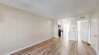 Located at 747 N Azusa Ave in West Covina, CA, this well-appointed one-bedroom, one-bathroom unit offers a thoughtfully designed single-floor layout with a clean, modern aesthetic throughout. Light-toned luxury vinyl plank flooring flows seamlessly across every room, complementing the neutral, warm-beige walls and crisp white trim to create a bright and cohesive atmosphere.

The open-concept living and dining area is generously proportioned, bathed in natural light from a large window fitted with vertical blinds. A wall-mounted air conditioning unit ensures year-round comfort. The space connects naturally to the kitchen, which features white cabinetry, a stainless steel gas range, a microwave, and a sink with ample counter space — making it both functional and efficient.

The bedroom offers a comfortable footprint, with a window that allows natural light to filter in. The unit includes three closets in total, providing exceptional storage capacity. Two hallways connect the main living areas to the private spaces, adding to the unit's smart flow.

The bathroom is cleanly finished with a marble-surround tub and shower combination, a white vanity with a marble-top, and a window for natural ventilation. A private patio extends the living space outdoors, ideal for relaxing or entertaining. The unit's clean finishes and practical layout make it an excellent option in the West Covina area.