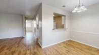 This 1-bedroom, 1-bathroom unit offers a thoughtfully designed single-floor layout that maximizes every square foot. Warm hardwood-style flooring flows consistently throughout all rooms, creating a cohesive and inviting atmosphere. The living area connects seamlessly to the dining room, which is brightened by a classic chandelier and features a pass-through window to the kitchen — an ideal detail for everyday functionality and ease of interaction between spaces.

The galley-style kitchen is efficiently arranged with white cabinetry, granite-style countertops, a full suite of white appliances including an electric range, microwave, refrigerator, and dishwasher, along with a double-basin sink. A textured ceiling adds a subtle design element visible throughout the unit.

The bedroom is a comfortable, well-proportioned room featuring a ceiling fan, a window with natural light and outdoor views, and access to a generously sized walk-in closet complete with dual hanging rods and a built-in shelf — offering ample organized storage.

The bathroom is clean and functional, featuring a tub/shower combination, a vanity with granite-style countertops, white cabinetry with overhead storage, and a mirror. The hardwood-style flooring continues here as well, tying the space together with a consistent, polished finish throughout.