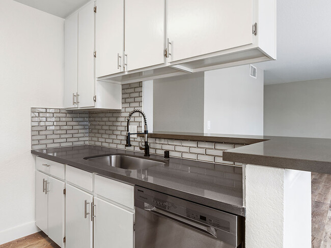 White tiled kitchen with stainless steel fixtures. - Magnolia Terrace