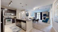 Located at 3201 Windshire Ln in Charlotte, NC, this thoughtfully designed two-bedroom, two-bathroom single-story residence offers a well-organized and comfortable layout. The open-concept living area seamlessly connects the kitchen, dining, and living spaces, creating an inviting environment ideal for both daily living and entertaining. The kitchen is outfitted with rich dark cabinetry, granite-style countertops, stainless steel appliances, and a central island with a sink, complemented by tile flooring. The living room features plush carpeting, a fireplace, track lighting, and French doors that invite abundant natural light and outdoor views. The primary bedroom is a generous retreat highlighted by a bold blue accent wall, carpeted floors, a ceiling fan, and direct access to a spacious walk-in closet with wire shelving. The en-suite bathroom includes a glass-enclosed shower, dark vanity cabinetry, and tile flooring. The second bedroom mirrors the same warm aesthetic with its own blue accent wall and natural light. A dedicated in-unit laundry room with full-size washer and dryer adds everyday convenience. Throughout the residence, a neutral color palette and consistent finishes create a cohesive and polished ambiance.