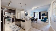 Located at 3201 Windshire Ln in Charlotte, NC, this thoughtfully designed two-bedroom, two-bathroom single-story residence offers a well-organized and comfortable layout. The open-concept living area seamlessly connects the kitchen, dining, and living spaces, creating an inviting environment ideal for both daily living and entertaining. The kitchen is outfitted with rich dark cabinetry, granite-style countertops, stainless steel appliances, and a central island with a sink, complemented by tile flooring. The living room features plush carpeting, a fireplace, track lighting, and French doors that invite abundant natural light and outdoor views. The primary bedroom is a generous retreat highlighted by a bold blue accent wall, carpeted floors, a ceiling fan, and direct access to a spacious walk-in closet with wire shelving. The en-suite bathroom includes a glass-enclosed shower, dark vanity cabinetry, and tile flooring. The second bedroom mirrors the same warm aesthetic with its own blue accent wall and natural light. A dedicated in-unit laundry room with full-size washer and dryer adds everyday convenience. Throughout the residence, a neutral color palette and consistent finishes create a cohesive and polished ambiance.