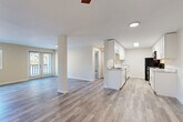 Located at 3816 156th St SW in Lynnwood, Washington, this one-bedroom, two-bathroom unit delivers a well-designed, single-floor layout with a clean, modern aesthetic throughout. Light-toned luxury vinyl plank flooring runs continuously across all living areas, creating a cohesive and bright feel.

The open-concept living and kitchen area is anchored by a thoughtfully designed galley-style kitchen featuring crisp white shaker cabinetry with sleek hardware, marble-look countertops, black appliances including a refrigerator, range, and over-the-range microwave, and a built-in sink. A peninsula-style counter connects the kitchen to the living space, enhancing the open flow. In-unit stacked laundry is conveniently tucked into a dedicated hallway closet.

The spacious living room benefits from a ceiling fan, a sliding glass door offering natural light and outdoor access, and warm neutral wall tones that complement the flooring throughout. A central column adds architectural character to the shared living space.

The generously sized bedroom features a large window with outdoor views, a standard closet, and an adjacent bathroom access point. The hallway connects both bathrooms, each finished with matching neutral tones and LVP flooring. The second bathroom includes a shower/tub combination.