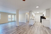 Located at 3816 156th St SW in Lynnwood, Washington, this one-bedroom, two-bathroom unit delivers a well-designed, single-floor layout with a clean, modern aesthetic throughout. Light-toned luxury vinyl plank flooring runs continuously across all living areas, creating a cohesive and bright feel.

The open-concept living and kitchen area is anchored by a thoughtfully designed galley-style kitchen featuring crisp white shaker cabinetry with sleek hardware, marble-look countertops, black appliances including a refrigerator, range, and over-the-range microwave, and a built-in sink. A peninsula-style counter connects the kitchen to the living space, enhancing the open flow. In-unit stacked laundry is conveniently tucked into a dedicated hallway closet.

The spacious living room benefits from a ceiling fan, a sliding glass door offering natural light and outdoor access, and warm neutral wall tones that complement the flooring throughout. A central column adds architectural character to the shared living space.

The generously sized bedroom features a large window with outdoor views, a standard closet, and an adjacent bathroom access point. The hallway connects both bathrooms, each finished with matching neutral tones and LVP flooring. The second bathroom includes a shower/tub combination.