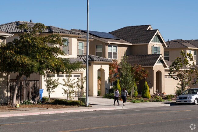 Locals walk beside a row of homes in Greenfield.