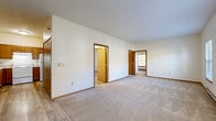 Located at 379 N Walden Ln in Wellington, Ohio, this single-floor, 2-bedroom, 1-bathroom home offers a practical and well-organized layout. The living room is a bright, open space featuring plush carpeting, neutral white walls, and multiple windows that allow natural light to fill the room. A wall-mounted A/C unit and baseboard heating are present throughout, ensuring year-round comfort. The combined dining and kitchen area features warm oak cabinetry, a coil-top electric range, and a full-size refrigerator, all set on easy-to-maintain luxury vinyl plank flooring. Both bedrooms are carpeted and feature windows with outdoor views and baseboard heating. The primary bedroom is a comfortable size and is accompanied by a generous walk-in closet outfitted with wire shelving systems. In total, the home includes four closets, providing ample storage throughout. The full bathroom features a tub-shower combo with clean white surrounds, vinyl plank flooring, and a wood-trimmed vanity. Warm wood-toned door and trim accents are consistent throughout the home, lending a cohesive and classic aesthetic. The single-story design ensures easy accessibility across all areas of this functional and well-maintained home.
