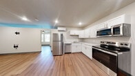 Located at 781 Fernwood Avenue in Fort Wayne, Indiana, this single-floor, one-bedroom, one-bathroom unit offers a clean, modern layout designed for comfortable everyday living. Luxury vinyl plank flooring runs consistently throughout the entire space, providing both durability and a cohesive aesthetic.

The combined kitchen and living area serves as the heart of the unit. The kitchen is outfitted with crisp white shaker-style cabinetry, light stone-look countertops, and a full suite of stainless steel appliances including a refrigerator, dishwasher, electric range, and over-the-range microwave. A wall-mounted mini-split HVAC unit provides efficient climate control. Recessed lighting illuminates the kitchen area effectively.

The living space flows naturally from the kitchen, offering an open and adaptable layout. The bedroom is a well-proportioned room featuring two large windows that invite generous natural light and offer views of the surrounding tree canopy. A ceiling fan with an integrated light fixture adds both comfort and functionality.

The bathroom is neatly designed with a white vanity, framed mirror, and a glass-enclosed shower stall, all finished with matching vinyl plank flooring. A closet and in-unit laundry area provide added convenience and practical storage for daily living.