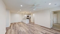 Located at 1200 Deana Rd in Ocean Springs, Mississippi, this single-floor home offers a clean, modern design with a bright and welcoming open-concept layout. The main living area is spacious and airy, finished with light-toned luxury vinyl plank flooring and recessed lighting that enhances the overall sense of openness. A ceiling fan adds both comfort and style to the living space, which flows naturally toward a well-appointed kitchen.

The kitchen serves as the heart of the home, anchored by a peninsula-style island with a double-basin stainless steel sink and elegant granite countertops. Pendant lighting hangs above the island, complementing the white shaker-style cabinetry and stainless steel appliances, including a microwave, range, and refrigerator. The open sightlines between the kitchen and living area make the space ideal for entertaining.

The bedrooms are carpeted for comfort and include ceiling fans and windows with blinds that allow natural light to filter in. The bathroom continues the home's refined aesthetic with granite countertops, white shaker cabinetry, a large mirror, and wood-look flooring. Throughout the home, neutral tones and consistent finishes create a cohesive, move-in-ready environment.