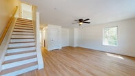 This well-appointed 2-bedroom, 3-bathroom home in Londonderry, NH is spread across three thoughtfully designed floors, offering generous living space throughout. Light hardwood flooring flows consistently across all levels, creating a bright and cohesive aesthetic complemented by crisp white walls and clean trim work.

The main living level features an open-concept kitchen and living area. The kitchen is equipped with rich dark wood cabinetry, granite countertops, stainless steel appliances including a range, microwave, dishwasher, and refrigerator, plus recessed lighting overhead. The combined living space provides a functional and welcoming layout ideal for everyday living and entertaining.

The upper floor houses the bedrooms, including a spacious primary bedroom with a ceiling fan, a private balcony accessed via sliding glass doors, and abundant natural light from multiple windows. The second bedroom is also well-sized, featuring a ceiling fan, natural light, and a closet. Three bathrooms serve the home, including one with a full tub-shower combination and granite vanity tops throughout.

The lower level offers a large, open finished space with recessed lighting, hardwood flooring, and additional windows, providing versatile square footage suitable for a recreation room, home office, or storage. A utility room and hallway round out the floor plan, completing this functional multi-level home.