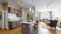Located at 120 Vintage Foxland Dr in Gallatin, TN, this thoughtfully designed 2-bedroom, 2-bathroom residence offers a comfortable and stylish single-floor layout. The open-concept kitchen is a standout feature, boasting granite countertops, grey shaker-style cabinetry, a white subway tile backsplash, and a full suite of stainless steel appliances. A central island with pendant lighting and bar seating connects seamlessly to the dining area and living room, creating an ideal space for entertaining. Crown molding and warm hardwood-style flooring flow throughout the main living areas, adding a refined touch. The dining area is defined by an archway entry, and the living room offers a relaxed ambiance with natural light filtering through large windows dressed with blinds and curtains. Both bedrooms feature plush carpeting and generous natural light, with the primary bedroom offering ample space and a well-organized closet. The bathrooms are finished with granite vanity tops, dark cabinetry, and tile flooring, with one bathroom featuring a full soaking tub and shower combination. A dedicated in-unit laundry area with built-in shelving adds everyday convenience, completing this functional and attractively finished home.