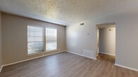 This single-floor, 2-bedroom, 1-bathroom residence offers a practical and cohesive layout designed for comfortable everyday living. Throughout the home, light wood-style laminate flooring provides a clean, consistent aesthetic, complemented by neutral warm-gray walls and textured ceilings.

The living room is a welcoming open space illuminated by natural light from a large window fitted with horizontal blinds. A pendant light fixture brightens the adjacent dining area, which connects seamlessly to the galley-style kitchen. The kitchen features gray cabinetry, white countertops, a double-basin sink, a dishwasher, and a stainless steel refrigerator, all arranged efficiently along a single corridor.

The primary bedroom is a generously sized room with two windows that invite abundant natural light and direct access to a dedicated closet. The second bedroom also offers comfortable proportions, corner windows for natural light, and its own closet with built-in shelving, alongside an additional separate closet nearby.

The full bathroom is clean and functional, appointed with gray vanity cabinetry, a quartz-style countertop, a large mirror, and a tiled shower-tub combination. A connecting hallway ties all rooms together, providing smooth circulation throughout the home. The overall ambiance is bright, neutral, and move-in ready.