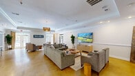 The Brixley at Carolina Forest community clubhouse in Myrtle Beach, SC, is a well-appointed single-floor facility designed to serve as a social and functional hub for its residents. The welcoming lobby greets visitors with polished concrete flooring, crown molding, arched transom windows, and French doors that flood the space with natural light and provide views of the surrounding outdoor areas.

The main lounge is an expansive, open gathering area featuring tray ceilings with detailed crown molding, warm concrete floors, and a comfortable seating arrangement centered around a large flat-screen TV. A pendant light fixture and a mix of sofas and accent chairs create an inviting, relaxed atmosphere, while a wall-mounted Brixley logo adds a branded sense of place.

A dedicated coworking room offers a productive environment with individual workstations along a long desk, a central round table with seating, and an arched window that brings in ample natural light. The room's slate-blue accent wall, complemented by abstract wall art, gives it a modern, focused feel.

The game room is a standout recreational space finished in deep blue-gray tones and carpeted flooring. It is equipped with a billiards table, ping-pong table, and air hockey table, along with multiple wall-mounted TVs. French doors connect the game room to adjacent areas, maintaining an open and social flow throughout the facility.