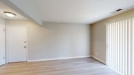 This single-floor unit at 16312 Hickory Pine Ln in Wildwood, Missouri offers a clean, well-maintained layout designed for functional everyday living. The interior is finished with neutral warm-gray walls and crisp white trim throughout, creating a cohesive and understated aesthetic.

The living areas feature light-toned hardwood-style flooring that extends through the main spaces, contributing to a bright and open feel. A sliding glass door fitted with vertical blinds allows natural light to filter into the living area while providing access to the outdoors. The layout, as visible in the floor plan, flows efficiently from the living space through a central corridor to the kitchen and bedroom areas.

The galley-style kitchen is well-appointed with white shaker cabinetry, brushed hardware, a marble-style tile backsplash, light countertops, and a full suite of stainless steel appliances including a range, dishwasher, refrigerator, and over-the-range microwave. Light wood-style flooring continues into the kitchen, maintaining visual consistency.

The bedrooms are carpeted in a warm tan tone, offering a comfortable contrast to the harder surfaces elsewhere. Windows provide natural light and outdoor views, while sliding closet doors open to roomy storage with built-in shelving and hanging rods. The overall ambiance is clean, neutral, and move-in ready.