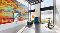 Located at 2121 Wood St in Oakland, CA, this fitness studio offers a dynamic and inspiring workout environment designed to motivate and energize. The space is defined by its striking architectural character, including soaring double-height ceilings and expansive floor-to-ceiling windows that flood the interior with abundant natural light, casting dramatic sun patterns across the polished concrete floors.

A standout feature is the large-scale, vibrant mural covering an entire wall, depicting an athletic figure set against an Oakland industrial waterfront backdrop — a vivid nod to the local character and culture. A full-length wall mirror amplifies the sense of openness and allows for form-checking during workouts.

The studio is equipped for a well-rounded fitness regimen, with equipment including a stationary cycling bike, plyo boxes, medicine balls, resistance tools, and a multi-use exercise mat station. Large glass sliding doors connect the space to an adjacent area with additional fitness equipment, offering flexibility and expanded training options.

The overall ambiance blends urban industrial aesthetics with a bright, clean, and energizing atmosphere. The combination of polished floors, white walls, bold artwork, and generous natural light creates a fitness environment that is both functional and visually compelling.