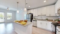 Located at 3014 Dr. Martin Luther King Jr. St. S in Saint Petersburg, FL, this well-designed 2-bedroom, 2-bathroom single-story home offers a clean, modern aesthetic throughout its efficiently laid-out floor plan. Light wood-style flooring flows seamlessly across every room, creating a bright and cohesive atmosphere.

The kitchen serves as the heart of the home, showcasing white shaker cabinetry with matte black hardware, granite countertops, a central island with pendant lighting, and a full suite of stainless steel appliances including a refrigerator, range, microwave, and dishwasher. The adjacent living room features a ceiling fan, a glass-panel entry door, and windows that invite generous natural light.

Both bedrooms are comfortably sized with large windows offering outdoor views and ample natural light. The primary bedroom includes a dedicated walk-in closet with wire shelving. The bathrooms mirror the home's modern style, featuring white cabinetry with granite countertops, light wood-style flooring, and a tub-shower combination. Two closets provide additional storage throughout the home.

The overall ambiance is light, airy, and move-in ready, with consistent finishes and a neutral color palette that lend the space a fresh, contemporary feel.