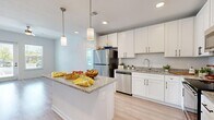 Located at 3014 Dr. Martin Luther King Jr. St. S in Saint Petersburg, FL, this well-designed 2-bedroom, 2-bathroom single-story home offers a clean, modern aesthetic throughout its efficiently laid-out floor plan. Light wood-style flooring flows seamlessly across every room, creating a bright and cohesive atmosphere.

The kitchen serves as the heart of the home, showcasing white shaker cabinetry with matte black hardware, granite countertops, a central island with pendant lighting, and a full suite of stainless steel appliances including a refrigerator, range, microwave, and dishwasher. The adjacent living room features a ceiling fan, a glass-panel entry door, and windows that invite generous natural light.

Both bedrooms are comfortably sized with large windows offering outdoor views and ample natural light. The primary bedroom includes a dedicated walk-in closet with wire shelving. The bathrooms mirror the home's modern style, featuring white cabinetry with granite countertops, light wood-style flooring, and a tub-shower combination. Two closets provide additional storage throughout the home.

The overall ambiance is light, airy, and move-in ready, with consistent finishes and a neutral color palette that lend the space a fresh, contemporary feel.