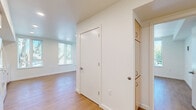 Located at 3097 SE Meek Street in Milwaukie, Oregon, this 2-bedroom, 2-bathroom unit offers a thoughtfully designed single-floor layout with clean, modern finishes throughout. Light wood laminate flooring runs through the main living areas, creating a warm, cohesive look.

The combined kitchen and living room forms the heart of the unit. The kitchen is well-equipped with light wood cabinetry, white appliances including a range, refrigerator, and dishwasher, along with light countertops and a single-basin sink. Recessed lighting and a large window brighten the space with natural light and outdoor greenery views.

The living area is open and airy, with large windows fitted with vertical blinds that frame views of the surrounding trees and grounds. A wall-mounted HVAC unit provides climate control convenience.

Both bedrooms continue the wood flooring aesthetic. The primary bedroom features a ceiling fan and a generous window with outdoor views. Each bedroom is served by its own bathroom — one featuring a double-sink vanity with light wood cabinetry, a wide mirror, and soft carpeted flooring, and the other a functional full bath with a soaking tub, grab bars, and neutral finishes. A central hallway connects all rooms efficiently, completing this clean and practical layout.