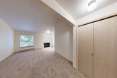 Located at 1923 Brittany Ln SW in Tumwater, WA, this single-floor, one-bedroom, one-bathroom unit offers a well-organized layout across a comfortable footprint. The combined living and dining area is a standout space, featuring vaulted ceilings, soft carpet flooring, a fireplace, and a large window that frames lush green views, filling the room with natural light. A baseboard heating system runs along the perimeter for year-round comfort. The kitchen is designed for efficiency, featuring white cabinetry with wood-tone trim, laminate countertops, a double-basin stainless steel sink, and white appliances including an electric range, microwave, and refrigerator. A peninsula counter provides additional prep space and serves as a natural divider between the kitchen and dining area. Wood-look flooring adds warmth underfoot. The bedroom is generously proportioned, offering high ceilings, plush carpeting, a window with natural light, and direct access to the bathroom and multiple closets, including a spacious walk-in closet fitted with wire shelving. The hallway connects the living spaces efficiently, with additional closet storage available. A dedicated laundry area, pantry, and private patio round out the functional amenities of this well-appointed Tumwater residence.