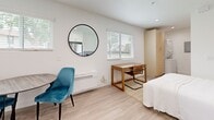 Located at 3364 Honeybrook Way in Ontario, California, this efficiently designed studio offers a thoughtfully organized single-floor layout that maximizes every square foot. The open-concept main area seamlessly integrates the living, sleeping, and dining zones, all finished with light-toned laminate wood flooring that lends warmth and visual continuity throughout the space. Natural light flows in through multiple windows fitted with white horizontal blinds, brightening the crisp white walls and creating an airy, welcoming atmosphere. A wall-mounted mini-split unit provides climate control, while recessed lighting adds to the clean, modern aesthetic.

The kitchen is well-appointed with stainless steel appliances, including a full-size refrigerator, electric range, over-the-range microwave, and dishwasher. White shaker-style cabinetry extends to the ceiling, offering generous storage, and is complemented by light quartz countertops and a stainless steel sink. A tall pantry cabinet provides additional organizational space.

The bathroom features a full tub-shower combination with built-in shelving, finished in bright white surround panels, paired with wood-look flooring for a clean, cohesive look. This studio is a practical and modern living solution in the Inland Empire region of Southern California.