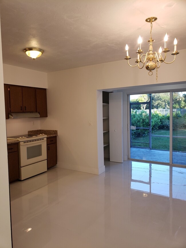 View from dining room, kitchen looking out of the sliding glass doors to back porch and yard - 11557 SW 81st Rd